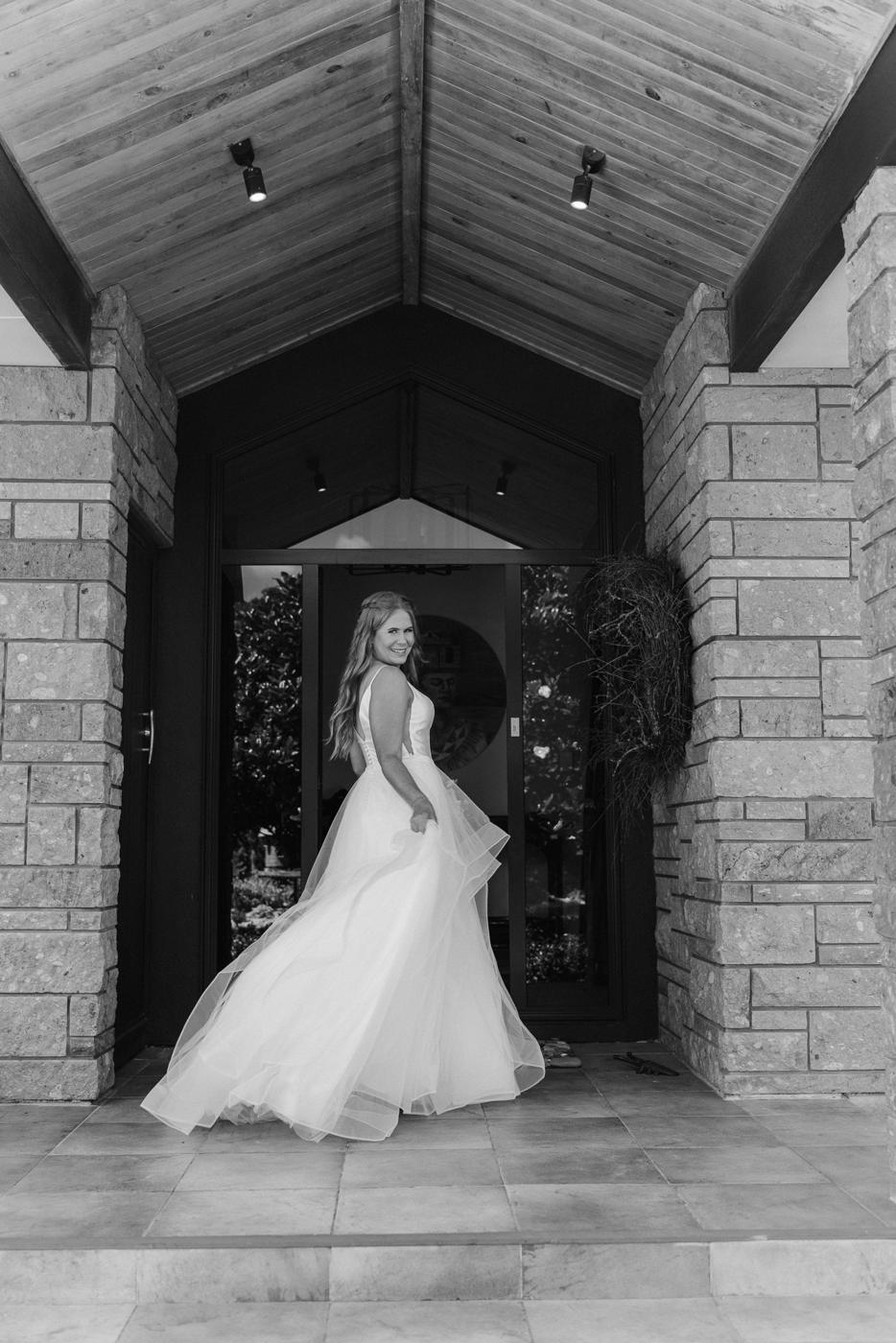 Black and white portrait of a bride standing in a doorway