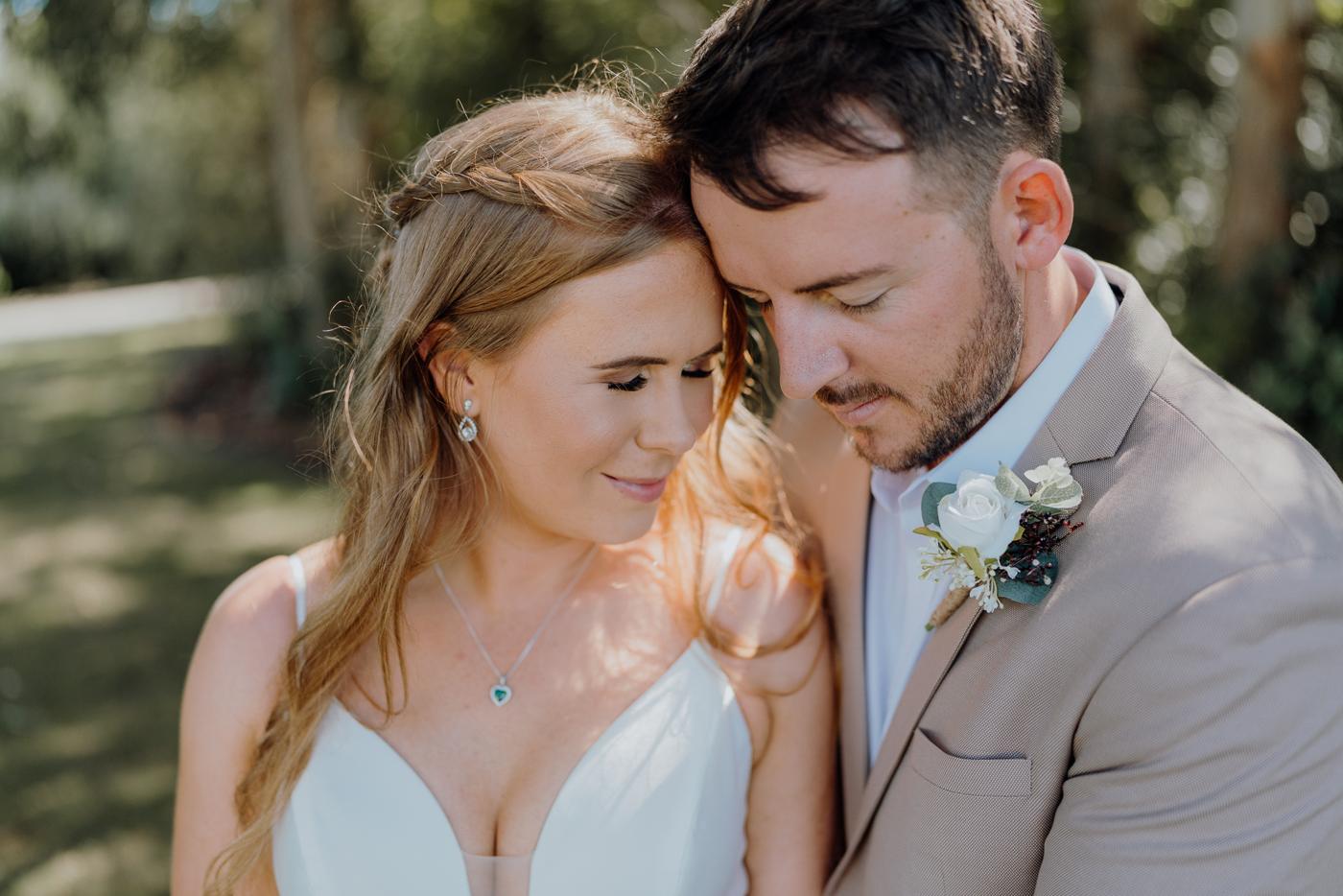 A bride and groom by a timber chapel