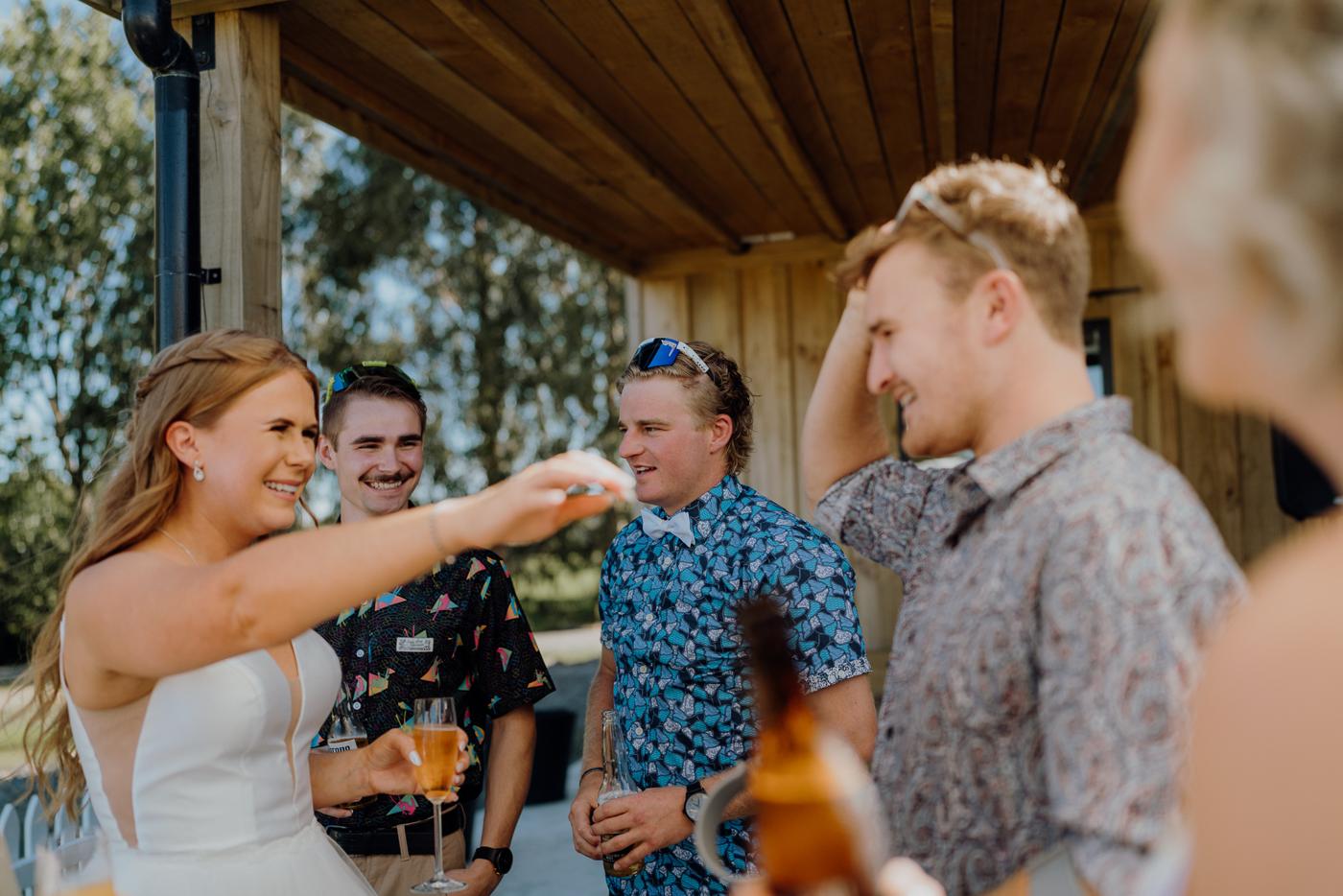 A bride laughing with guests on a covered veranda