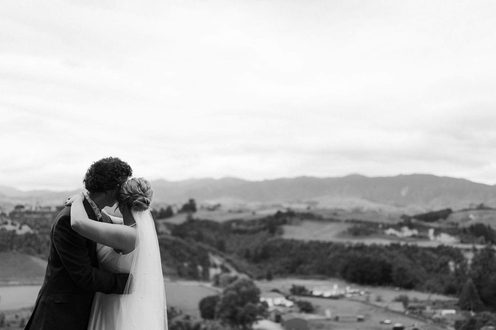 A couple embracing high above a valley, in black and white
