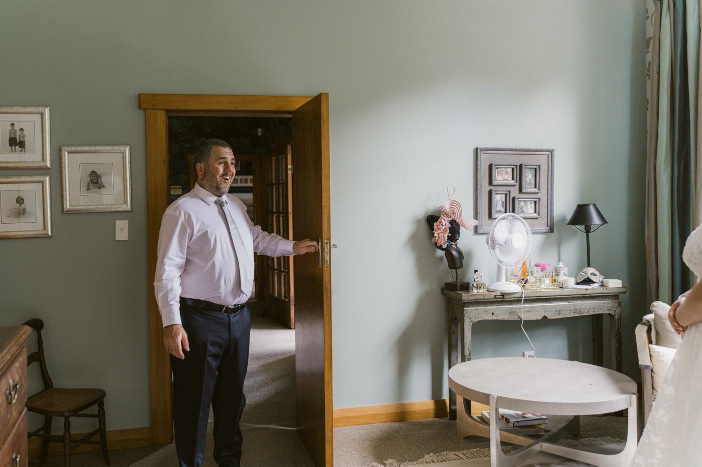 A father standing at a bedroom door as his daughter prepares