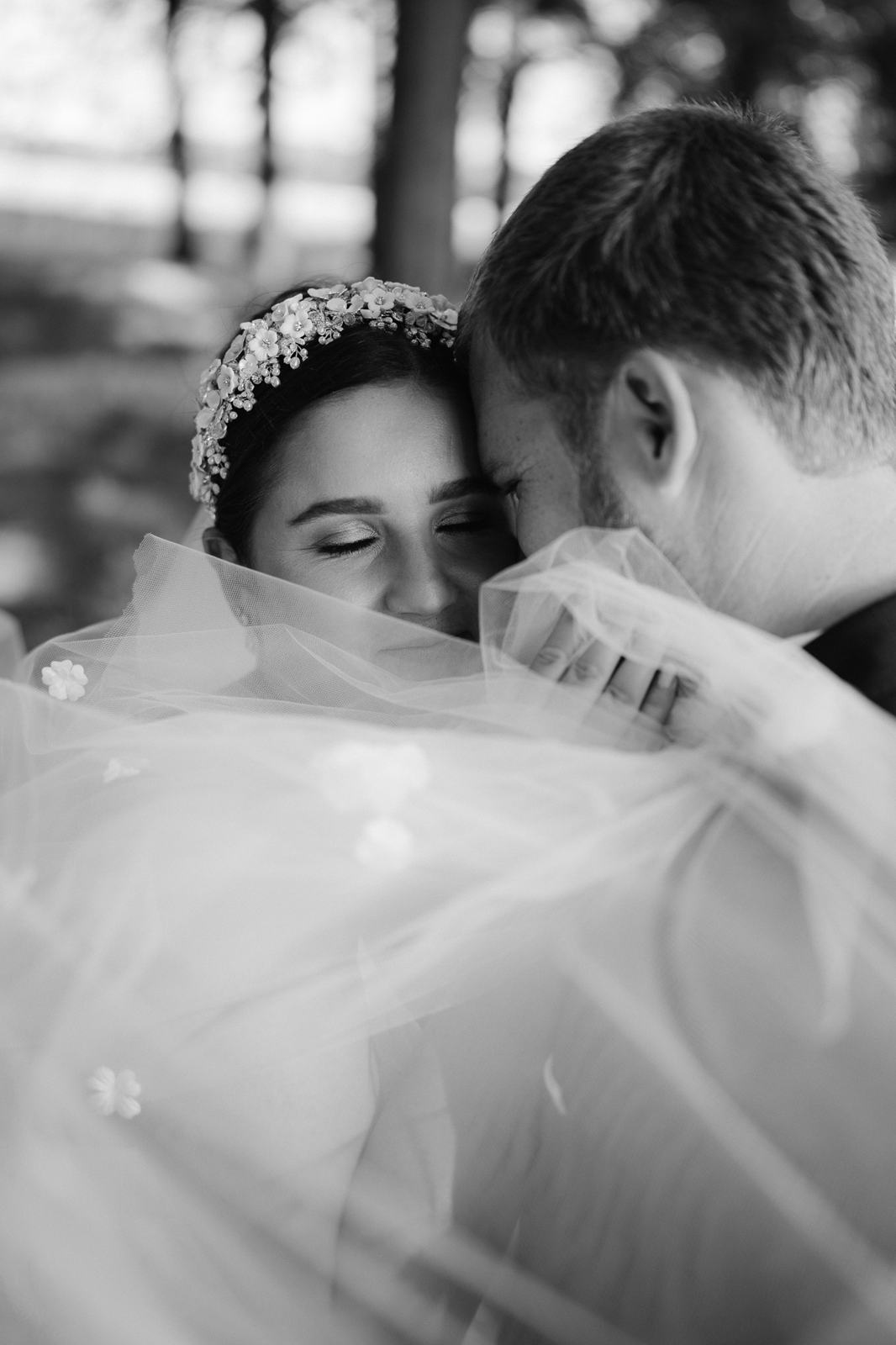 Black and white portrait of a bride with her eyes closed under her veil