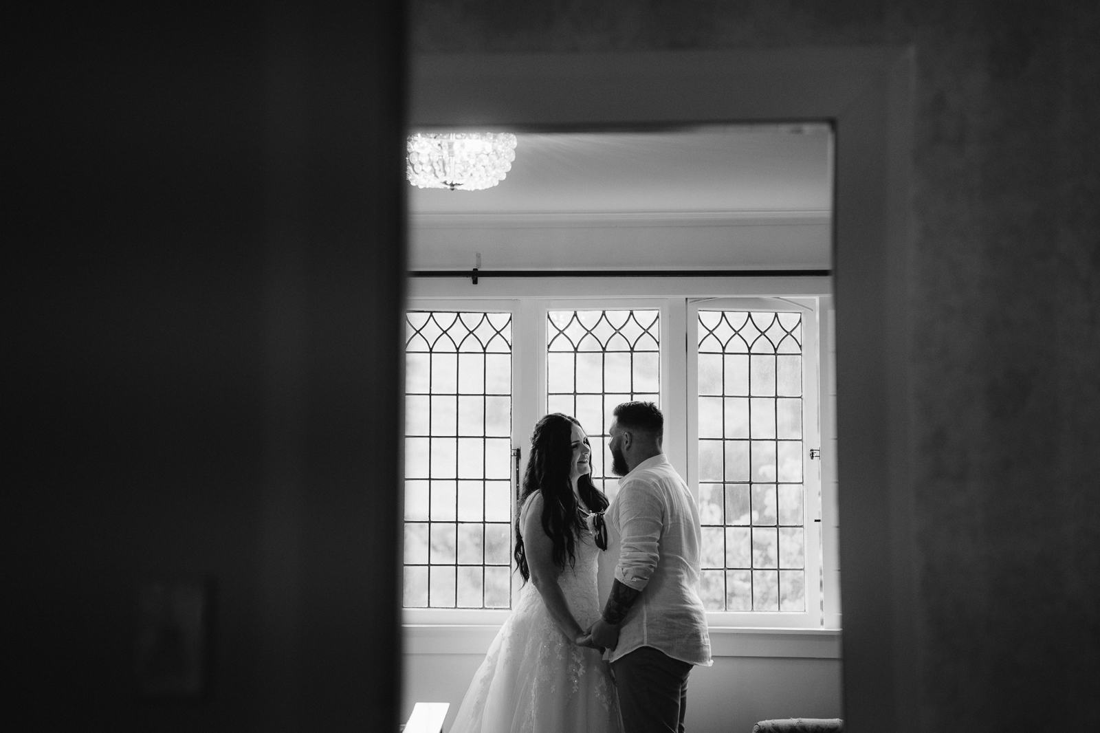 A couple in a window frame, in black and white