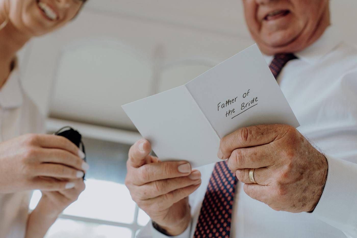 A father reading a handwritten card before the wedding