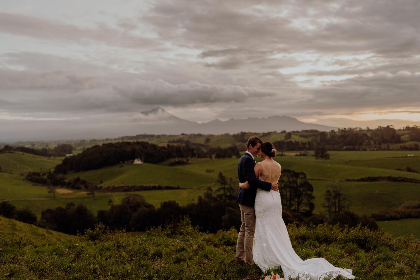 A couple embracing on a hill at dusk