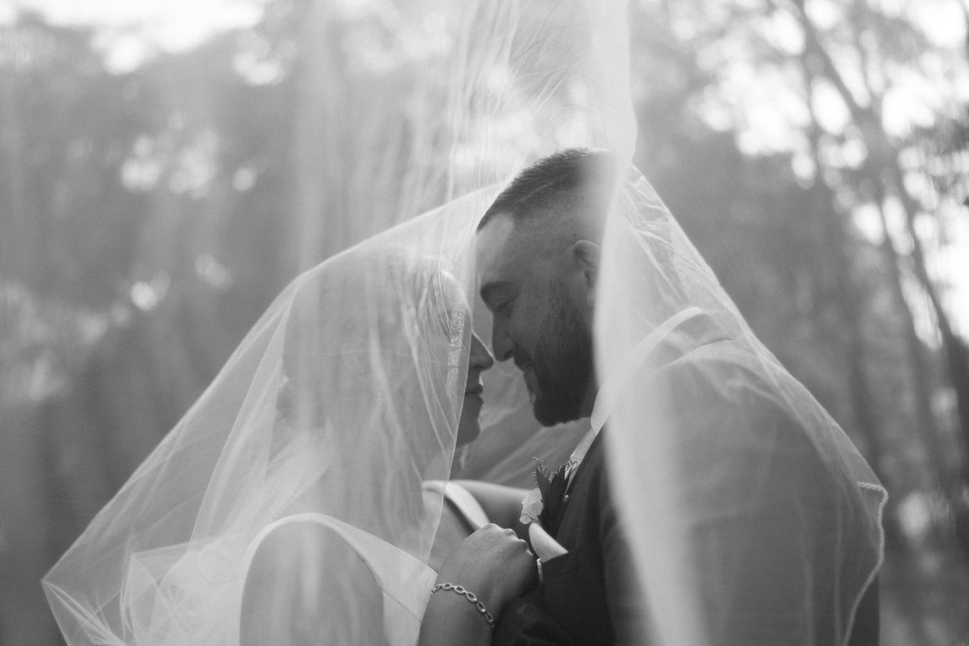 A couple under a veil in soft light, in black and white