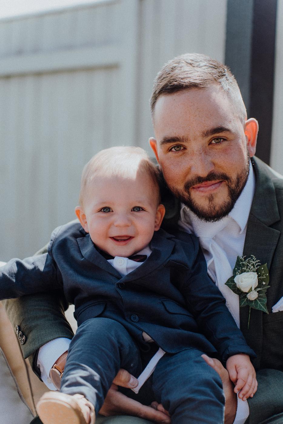 A groom holding his baby son