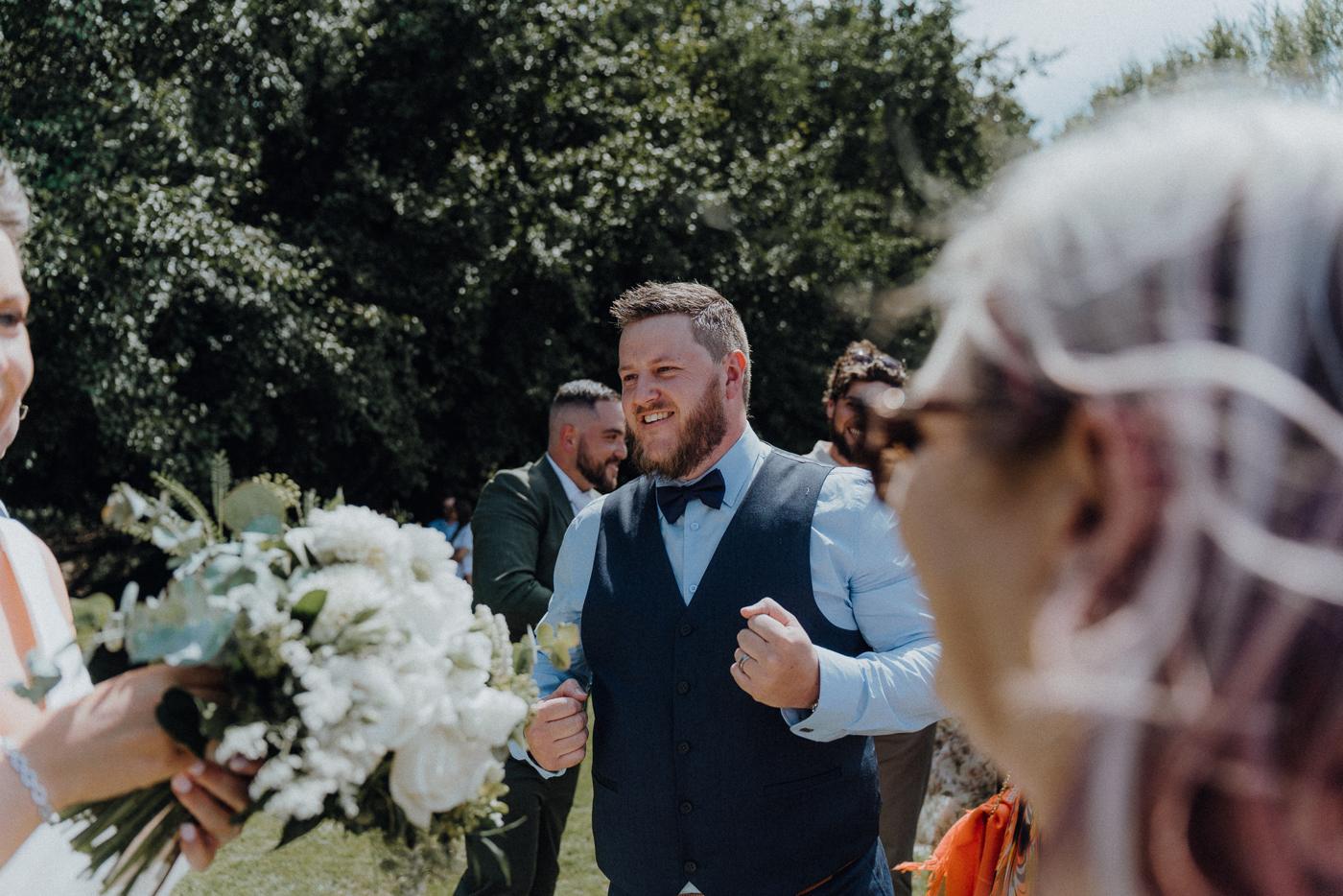 A groom reacting at his ceremony as the bride walks down the aisle