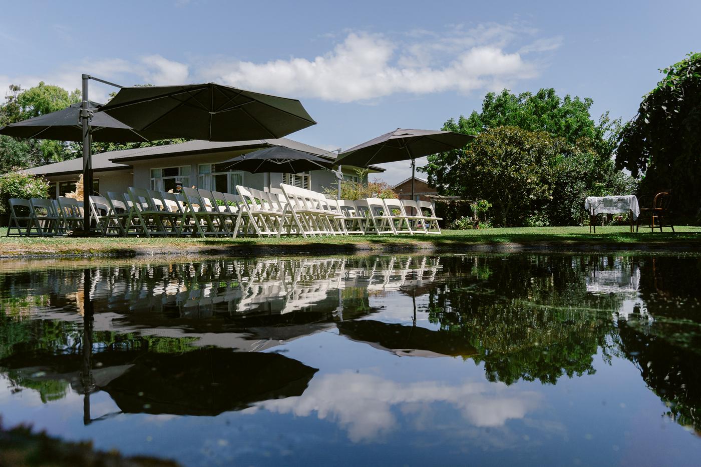 A reception marquee reflected in a pond