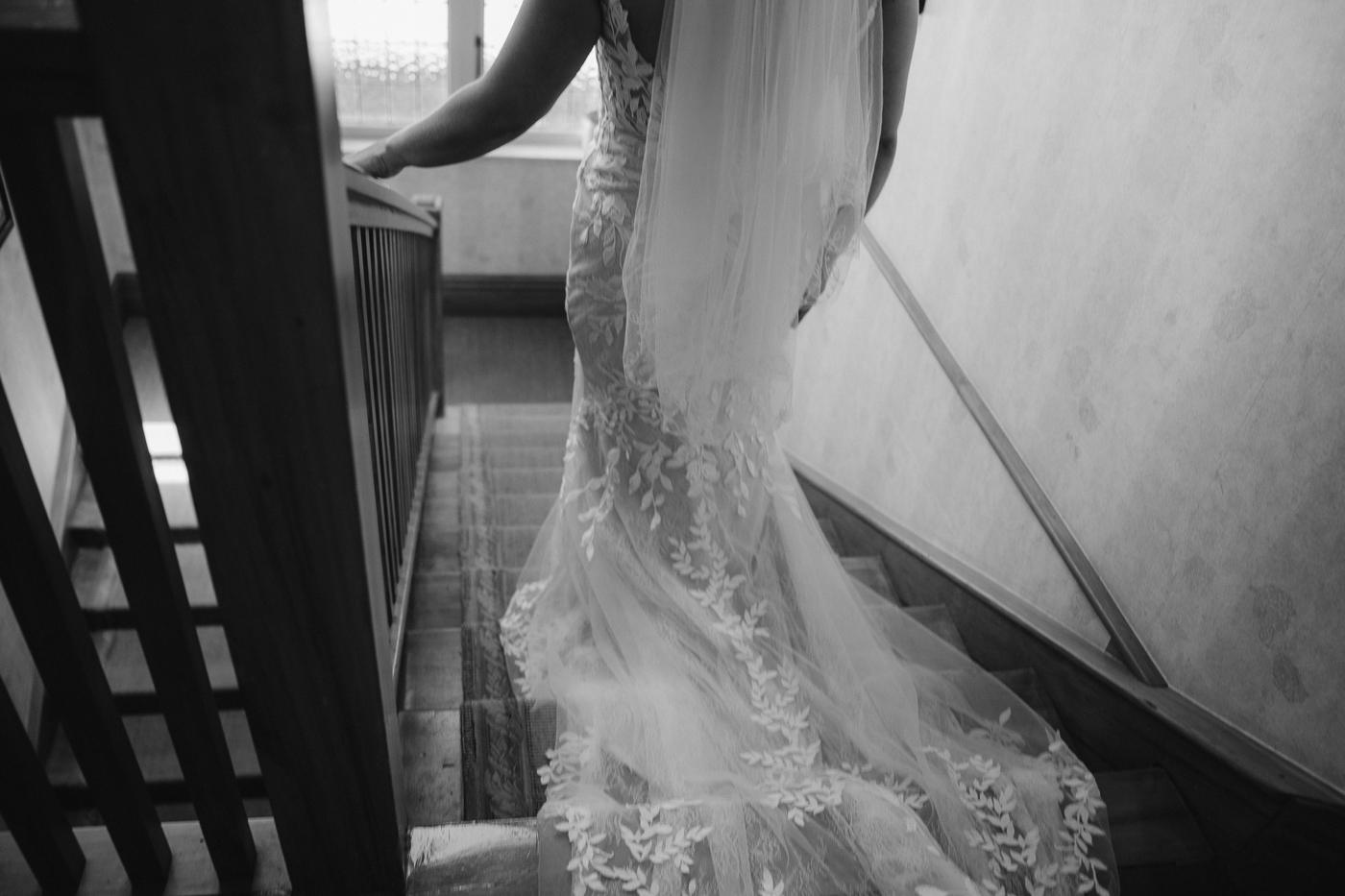A bride's dress and train on a staircase in black and white