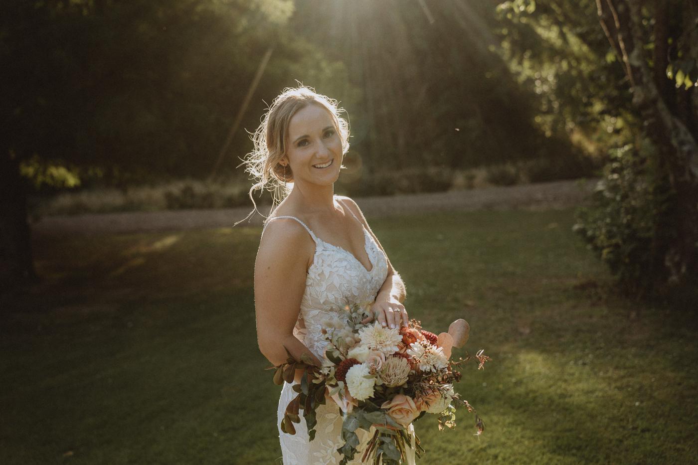 A bride in golden low light with a bouquet