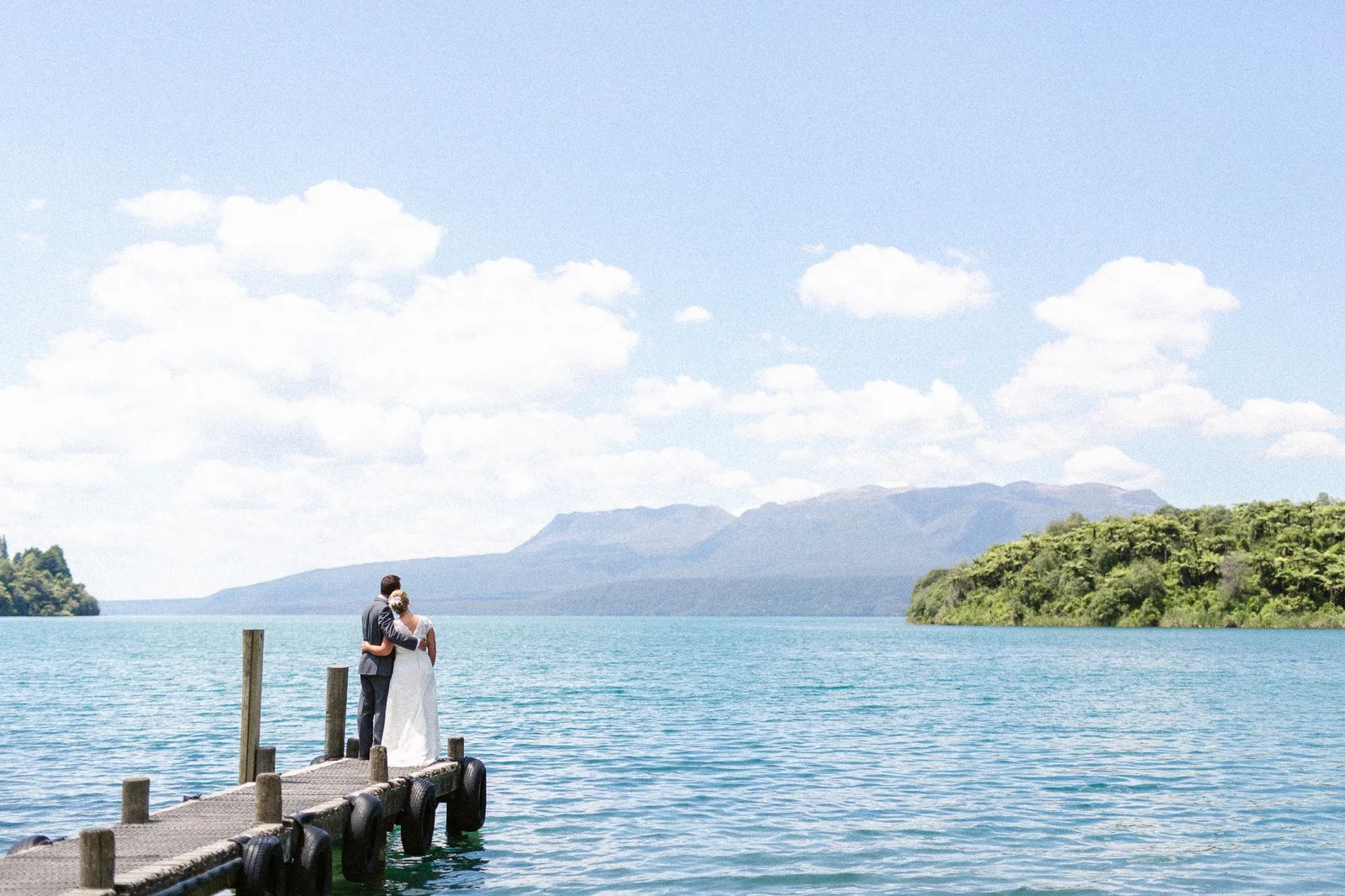 A couple embracing at the end of a lakeside jetty